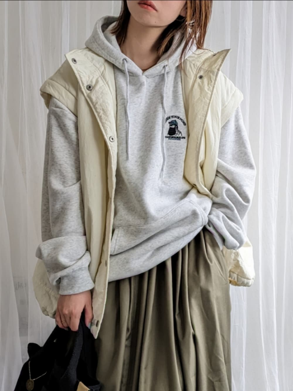 ホワイト系のダウンジャケット/コート、グレー系のパーカー、グリーン系のスカートを着用したレディースの春コーディネートの3枚目の写真