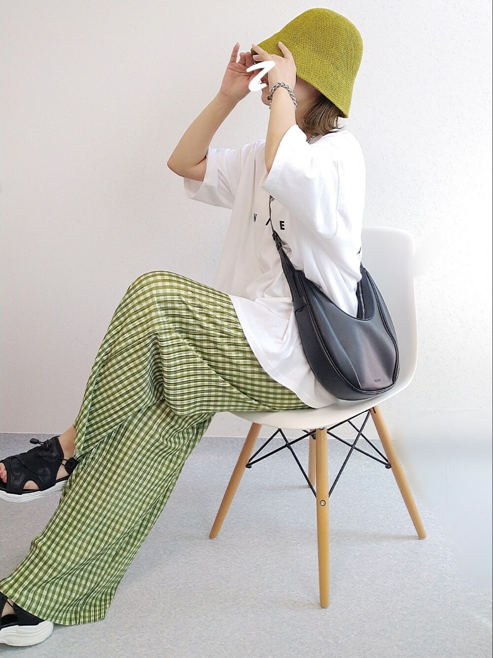 ホワイト系のTシャツ/カットソー、グリーン系のその他パンツ、ブラック系のサンダルを着用したレディースの春コーディネートの4枚目の写真