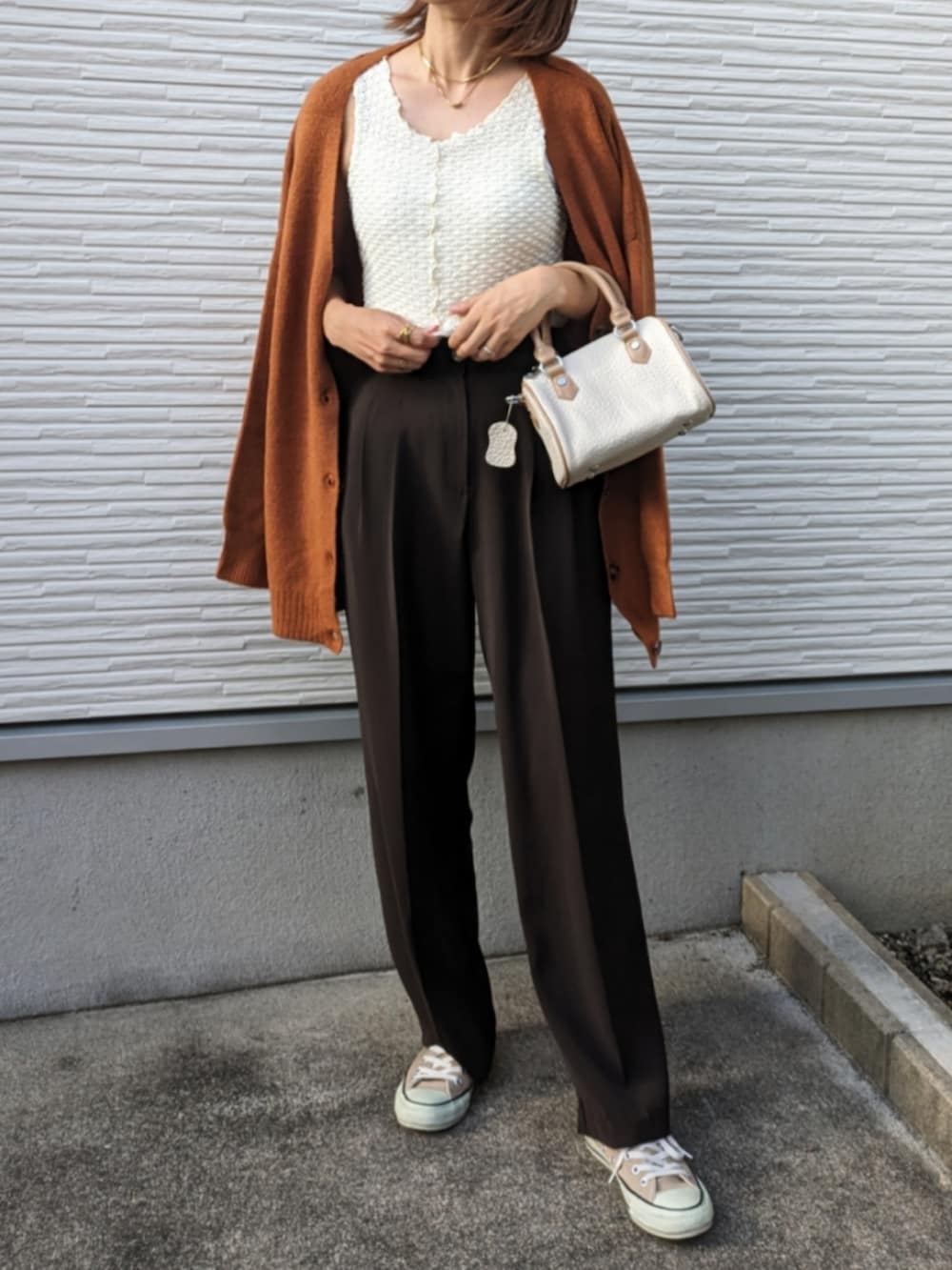 オレンジ系のカーディガン/ボレロ、ホワイト系のタンクトップ、ホワイト系のボストンバッグを着用したレディースの夏コーディネートの2枚目の写真