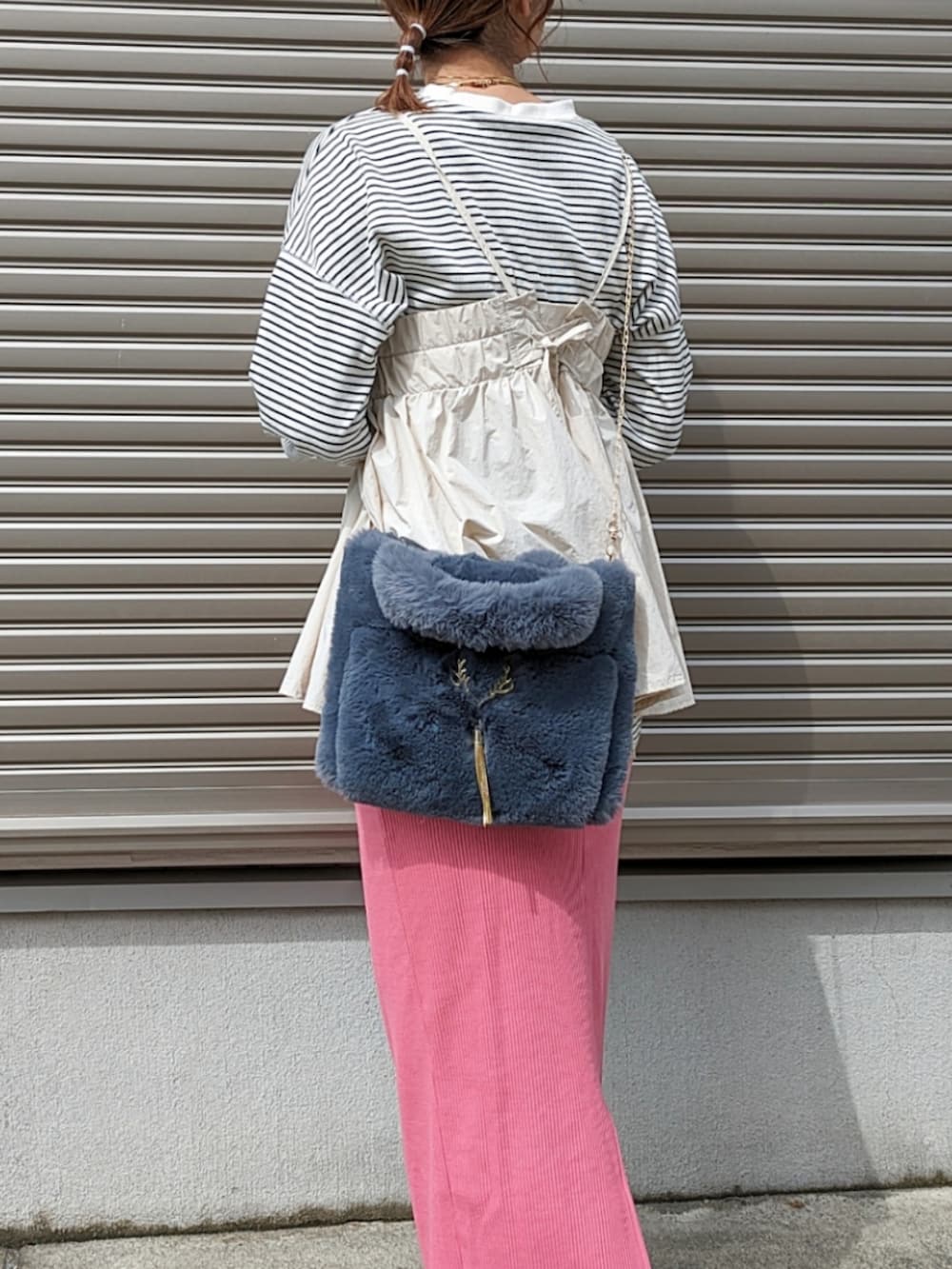 ベージュ系のTシャツ/カットソー、グレー系のハンドバッグ、ピンク系のスカートを着用したレディースの秋コーディネートの4枚目の写真