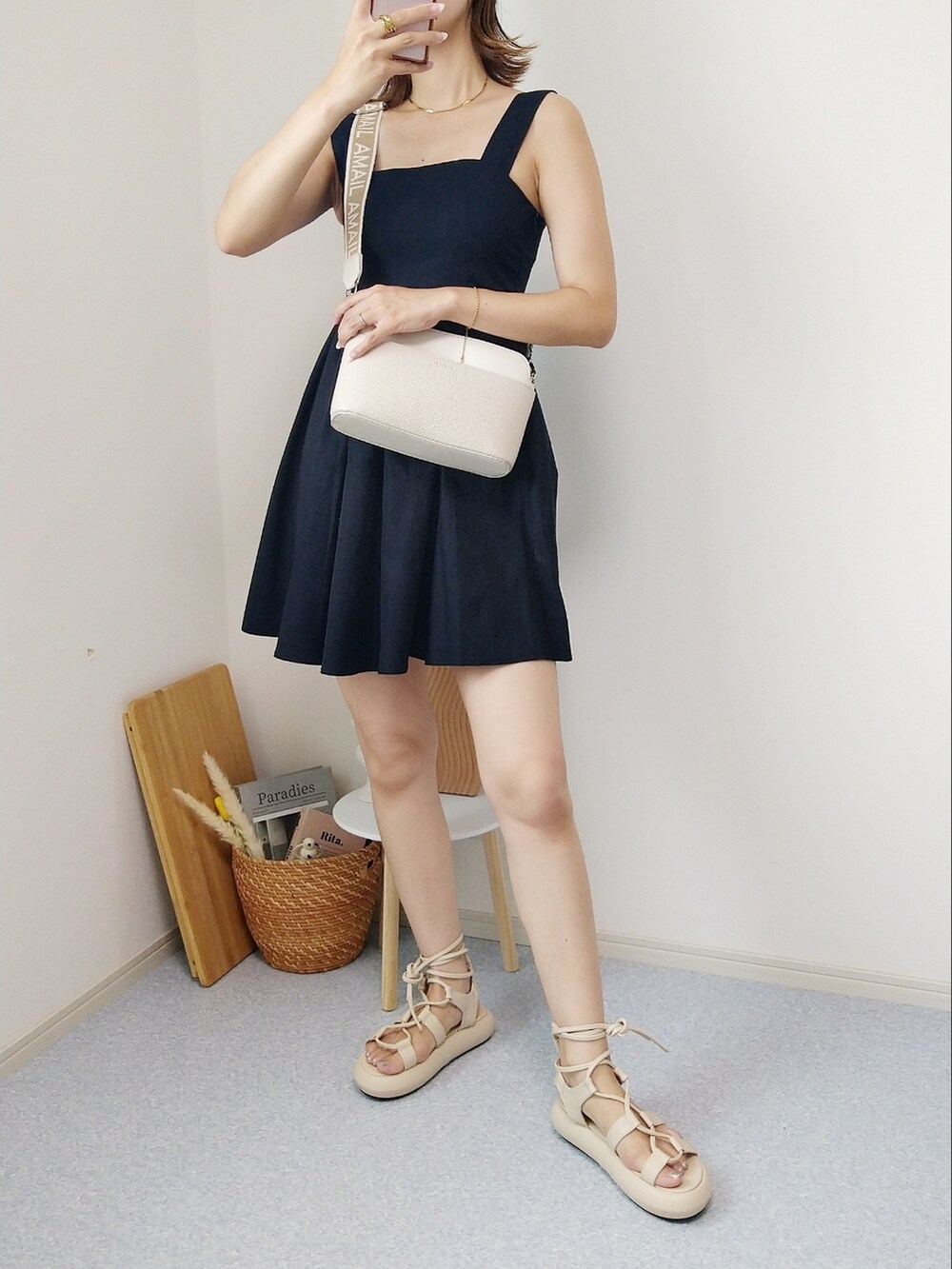 ブラック系のワンピース、ベージュ系のショルダーバッグ、ベージュ系のサンダルを着用したレディースの夏コーディネートの2枚目の写真