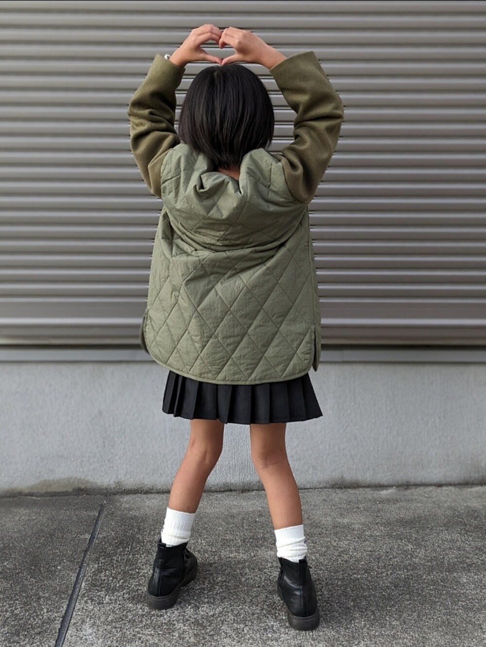 ブラック系のブーツ、グリーン系のニット/セーター、グリーン系のブルゾンを着用したキッズの秋コーディネートの4枚目の写真