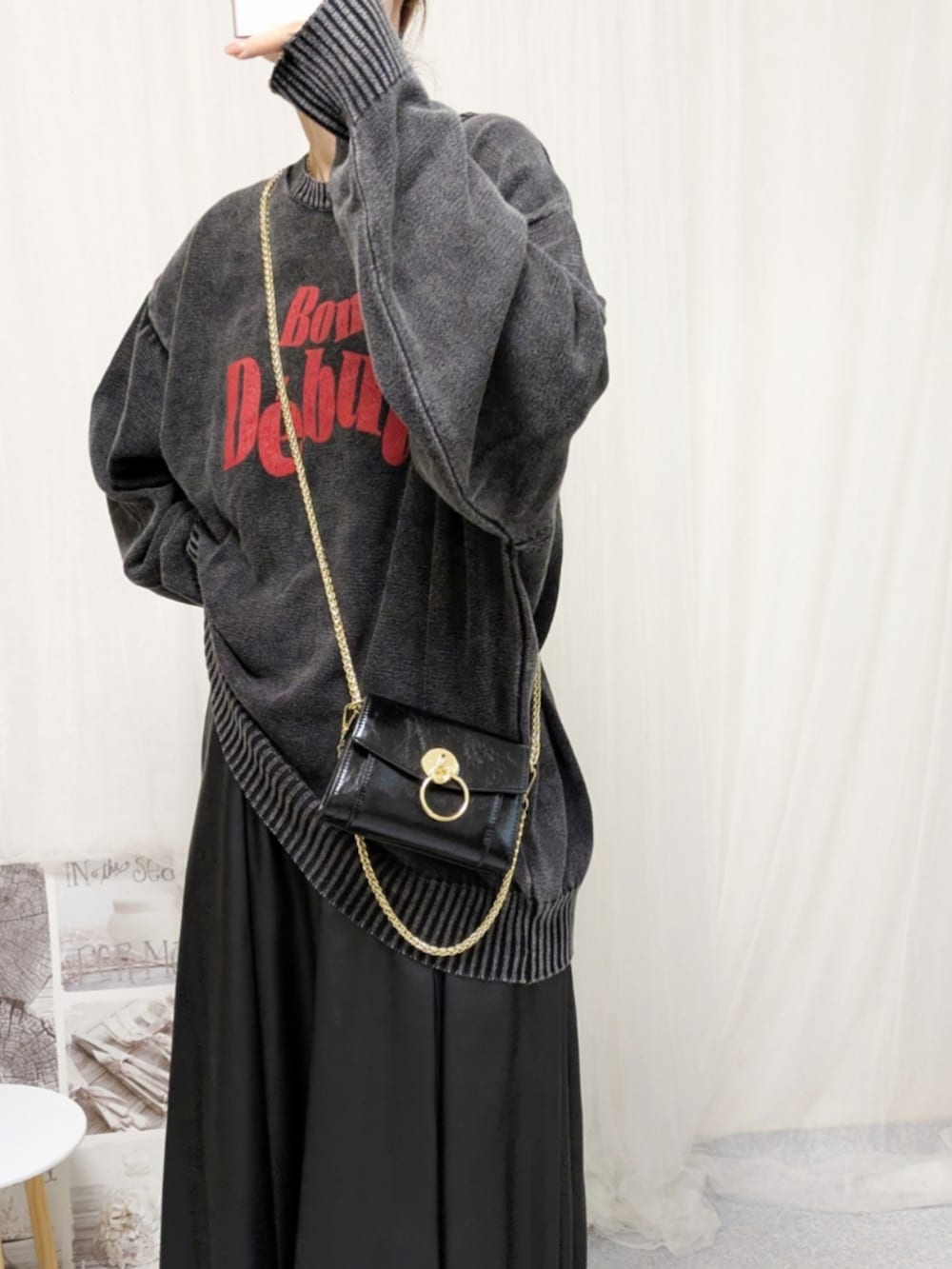 ブラック系のブーツ、ブラック系のニット/セーター、ブラック系のバッグを着用したレディースの秋コーディネートの4枚目の写真