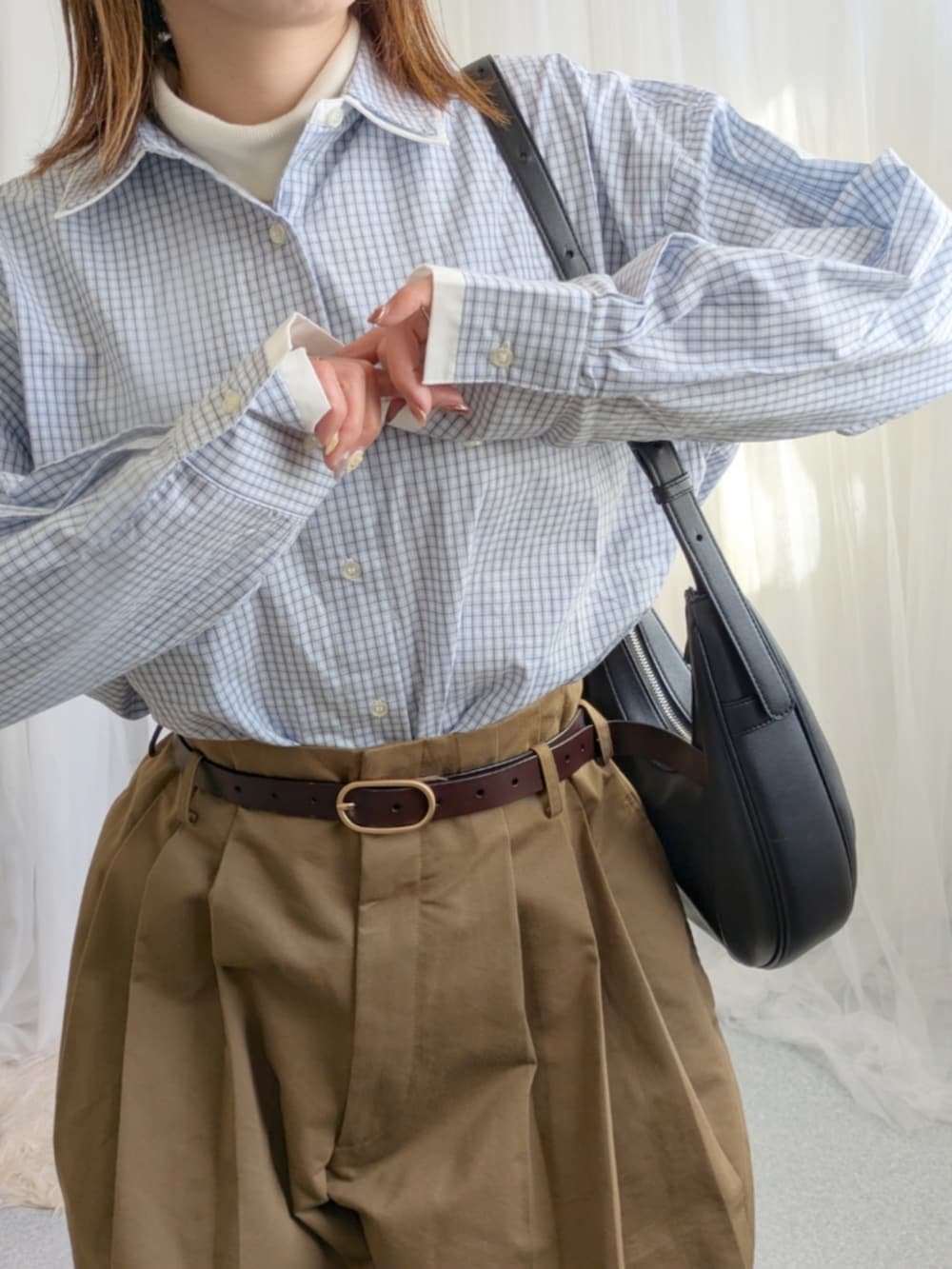 ブルー系のシャツ/ブラウス、ブラック系のバッグ、ブラウン系のパンツを着用したレディースの冬コーディネートの2枚目の写真