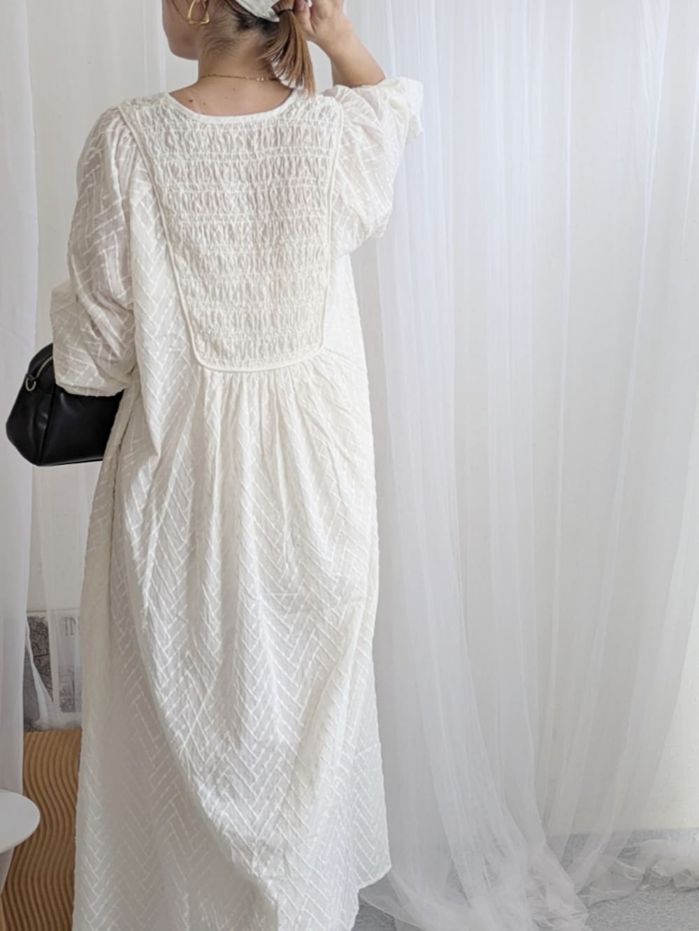 ブラック系のブーツ、ホワイト系のワンピース、ホワイト系のキャップを着用したレディースの夏コーディネートの3枚目の写真