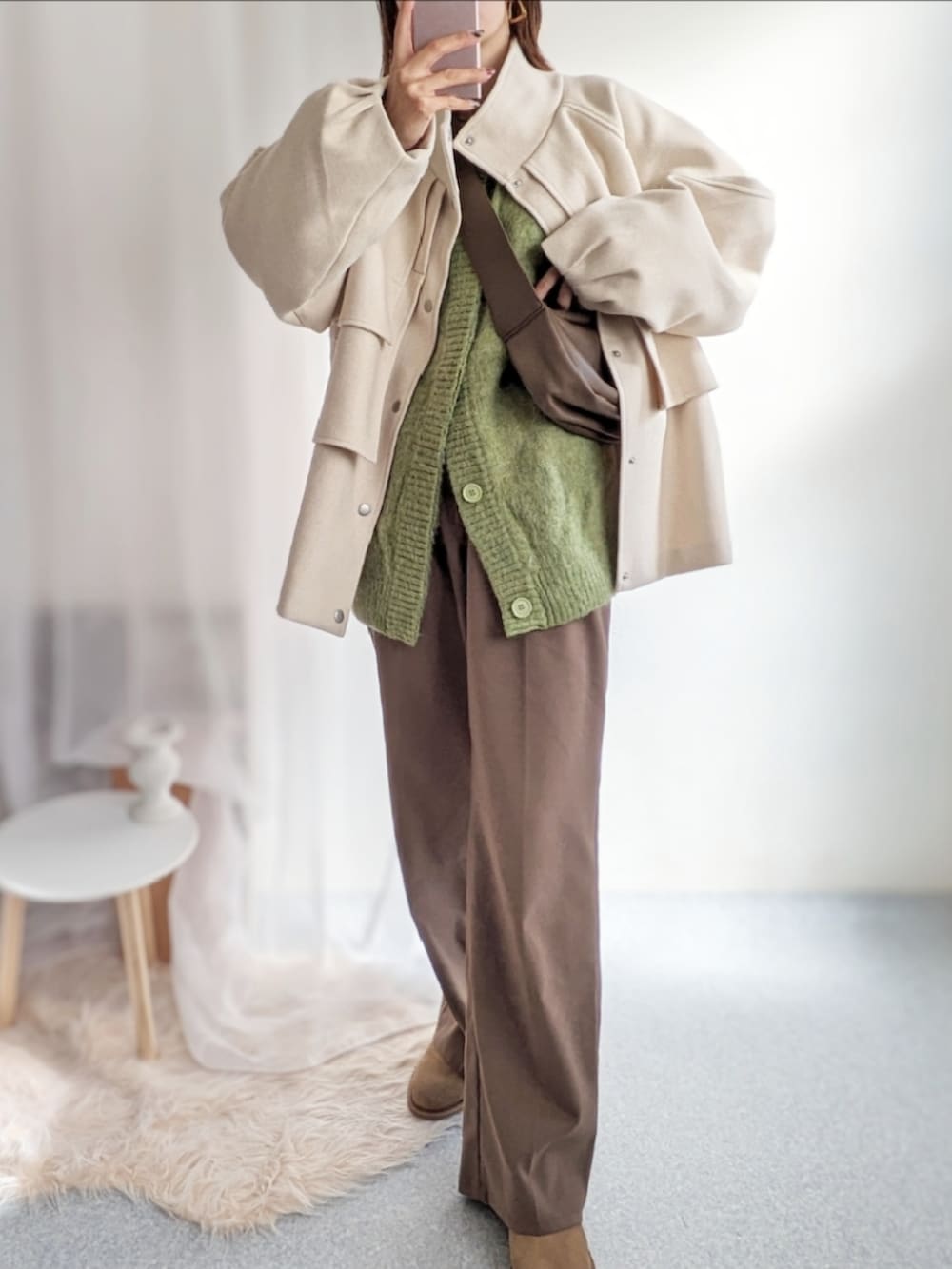 ブラウン系のショルダーバッグ、ホワイト系のその他アウター、グリーン系のカーディガン/ボレロを着用したレディースの秋コーディネートの4枚目の写真