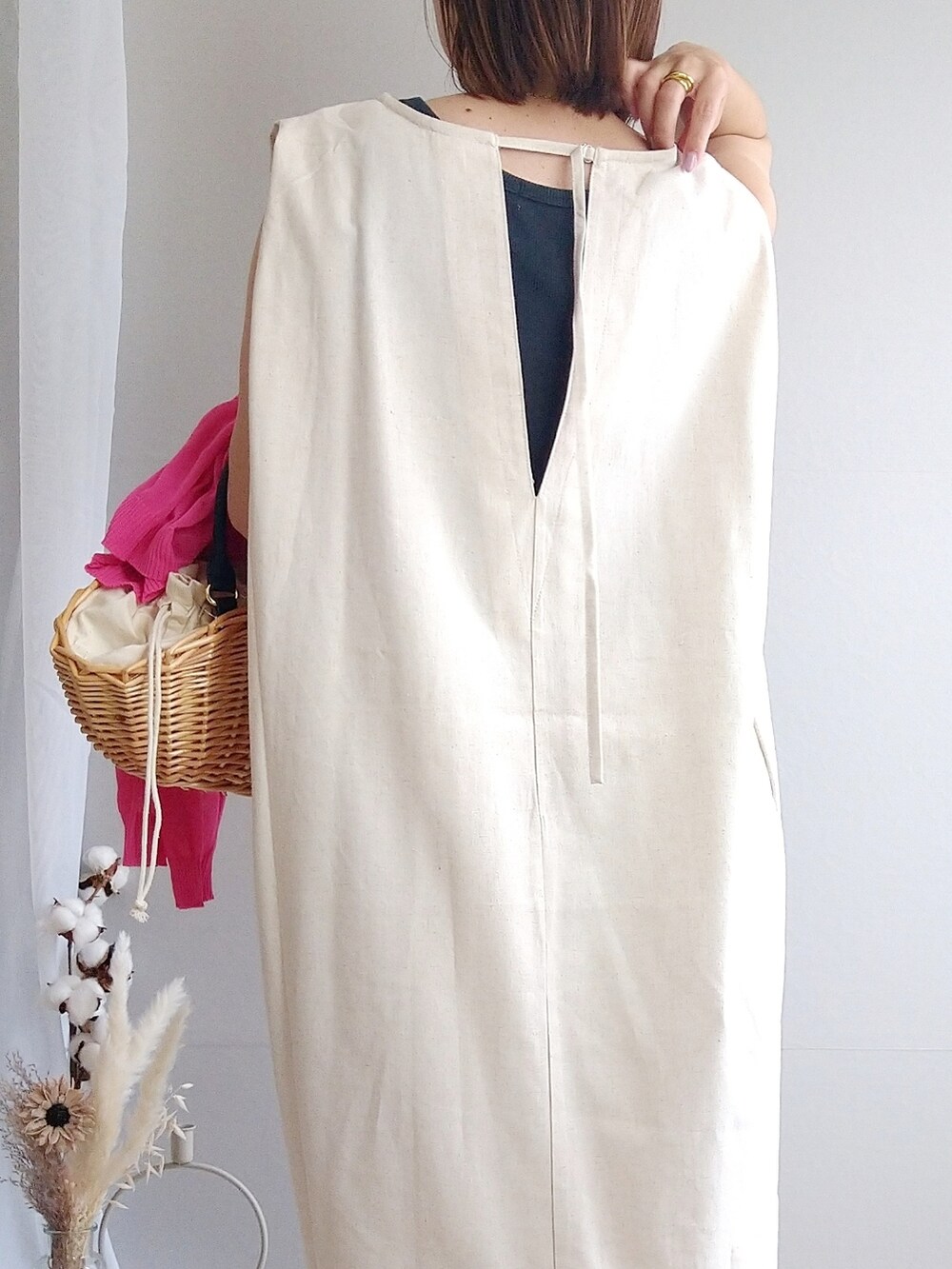 ベージュ系のバッグ、ピンク系のカーディガン/ボレロ、ホワイト系のワンピースを着用したレディースの春コーディネートの3枚目の写真