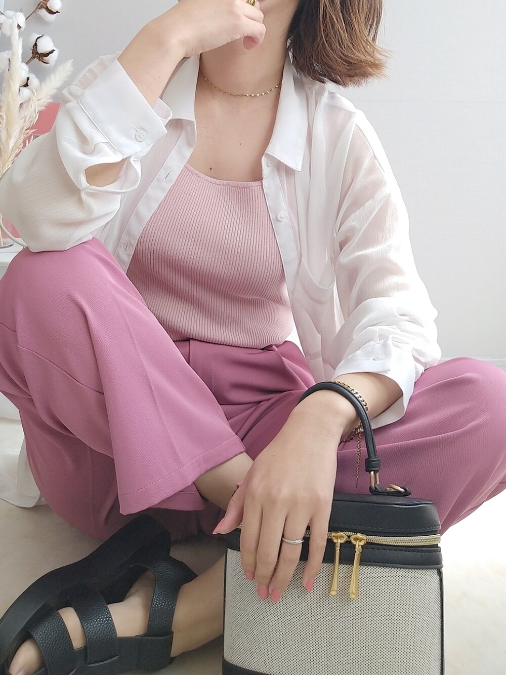 ピンク系のトップス、ピンク系のスラックス、ブラック系のサンダルを着用したレディースの春コーディネートの3枚目の写真