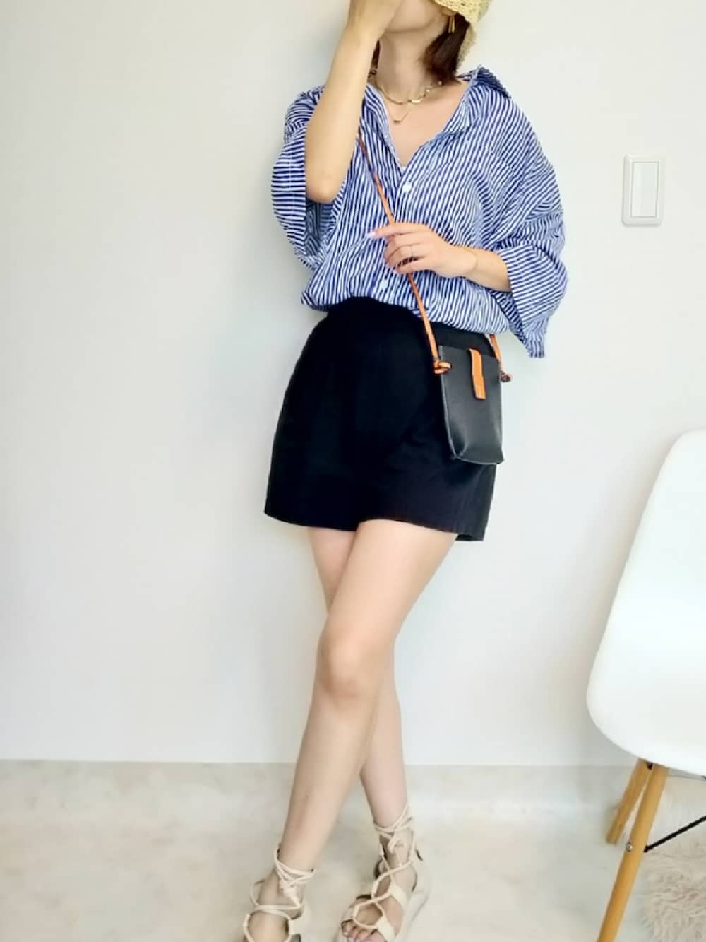 ブルー系のシャツ/ブラウス、ブラック系のショルダーバッグ、ベージュ系のサンダルを着用したレディースの夏コーディネートの2枚目の写真