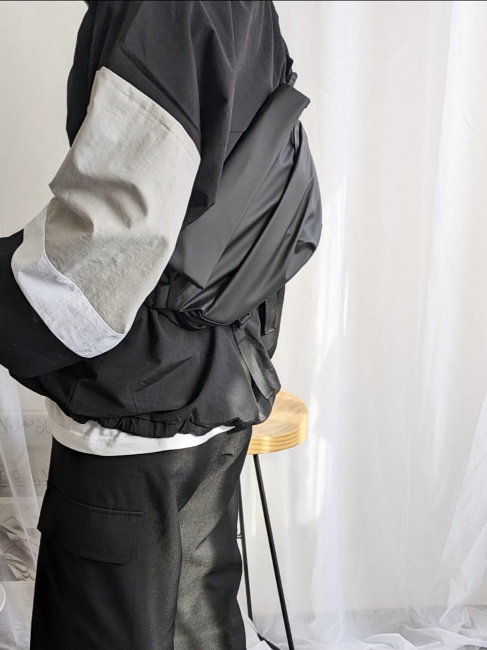 ブラック系のその他パンツ、ブラック系のナイロンジャケット、ブラック系のメッセンジャーバッグを着用したレディースの冬コーディネートの2枚目の写真