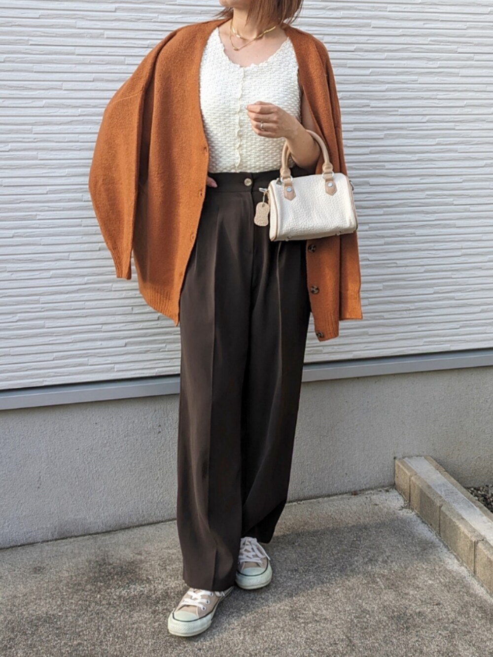 オレンジ系のカーディガン/ボレロ、ホワイト系のタンクトップ、ホワイト系のボストンバッグを着用したレディースの夏コーディネートの4枚目の写真