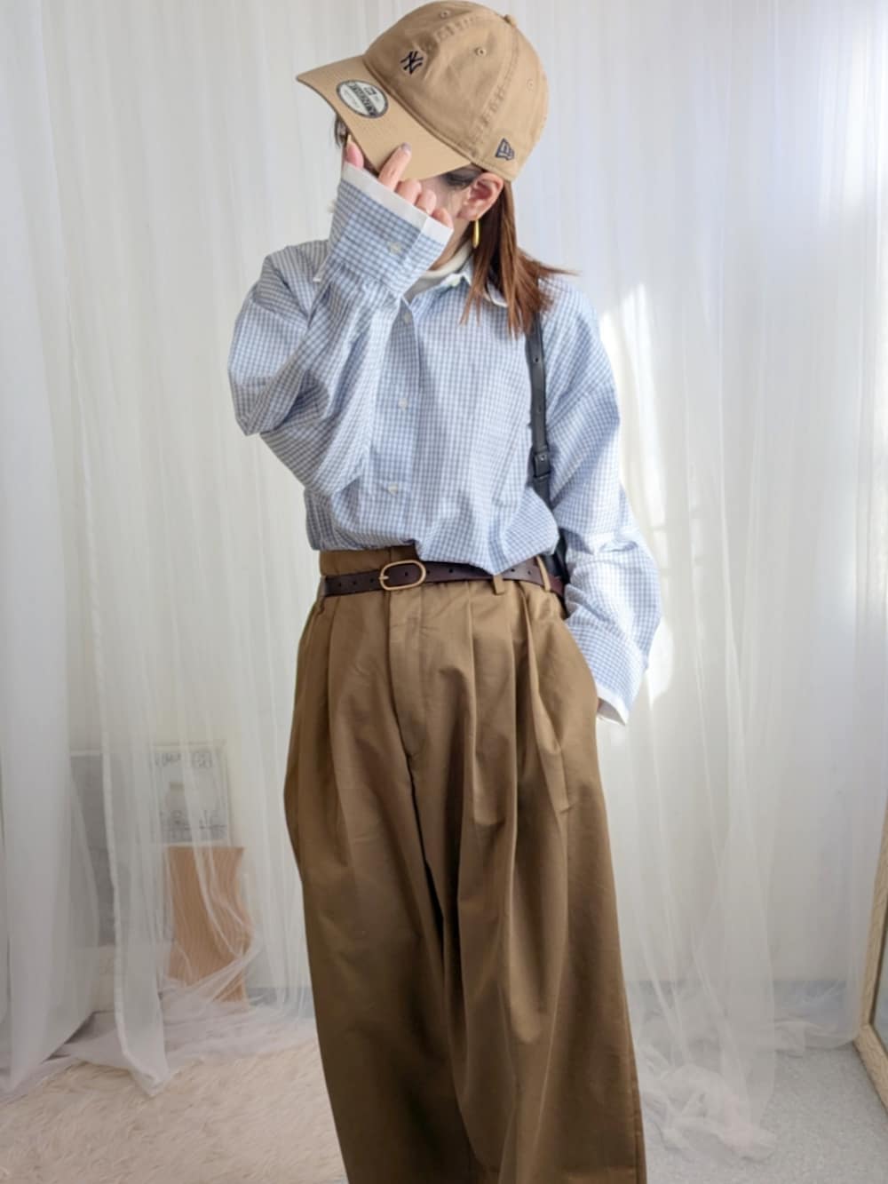 ブルー系のシャツ/ブラウス、ブラック系のバッグ、ブラウン系のパンツを着用したレディースの冬コーディネートの4枚目の写真