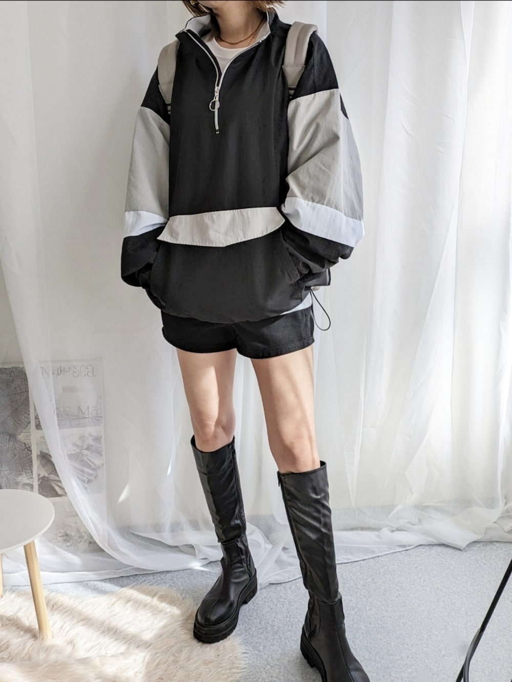 ブラック系のナイロンジャケット、ブラック系のデニムパンツ、ホワイト系のTシャツ/カットソーを着用したレディースの冬コーディネートの4枚目の写真