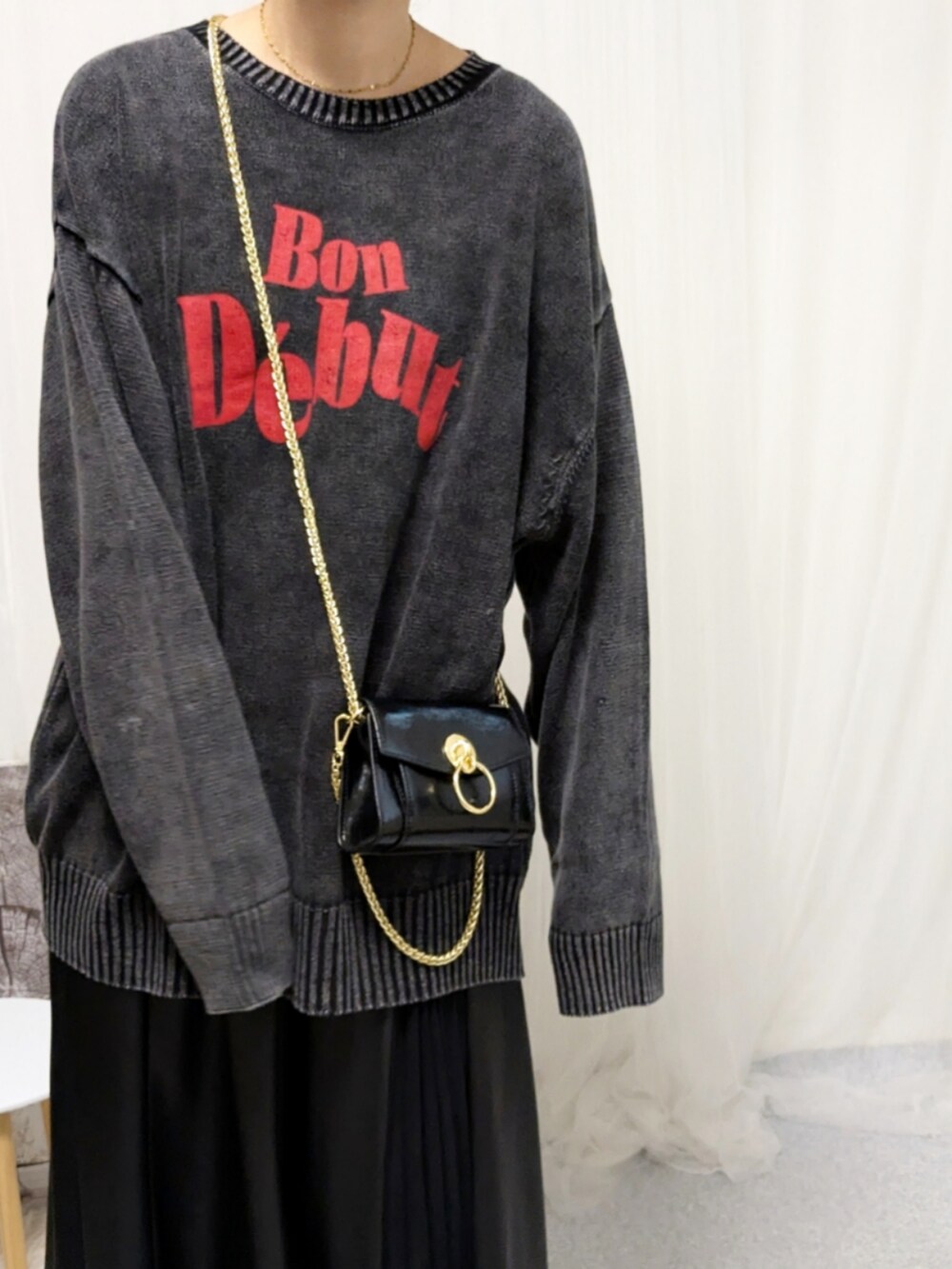 ブラック系のブーツ、ブラック系のニット/セーター、ブラック系のバッグを着用したレディースの秋コーディネートの3枚目の写真