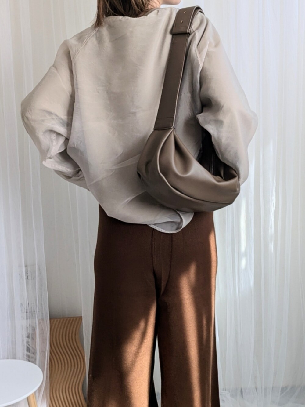 ブラウン系のその他パンツ、ブラウン系のショルダーバッグ、ベージュ系のTシャツ/カットソーを着用したレディースの秋コーディネートの2枚目の写真