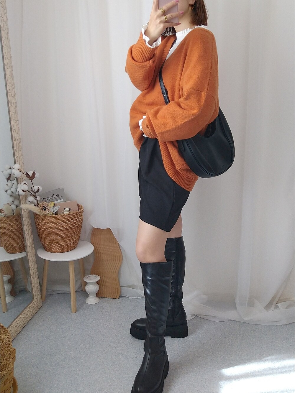 オレンジ系のニット/セーター、ホワイト系のシャツ/ブラウス、ブラック系のバッグを着用したレディースの秋コーディネートの2枚目の写真