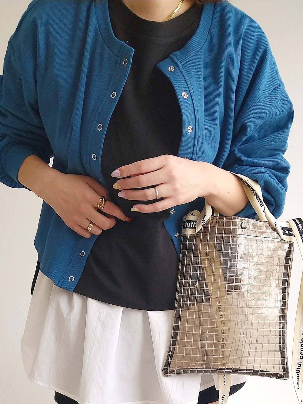 ブルー系のカーディガン/ボレロ、ブラック系のアンサンブル、ブラック系のショルダーバッグを着用したレディースの春コーディネートの3枚目の写真