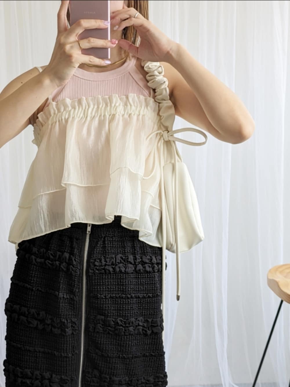 ホワイト系のショルダーバッグ、ブラック系のスカート、ホワイト系のキャミソールを着用したレディースの夏コーディネートの3枚目の写真