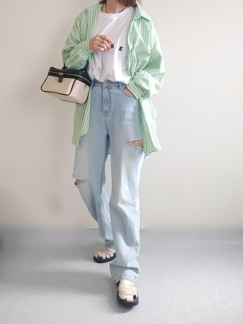 グリーン系のシャツ/ブラウス、ホワイト系のTシャツ/カットソー、ブラック系のハンドバッグを着用したレディースの春コーディネートの2枚目の写真