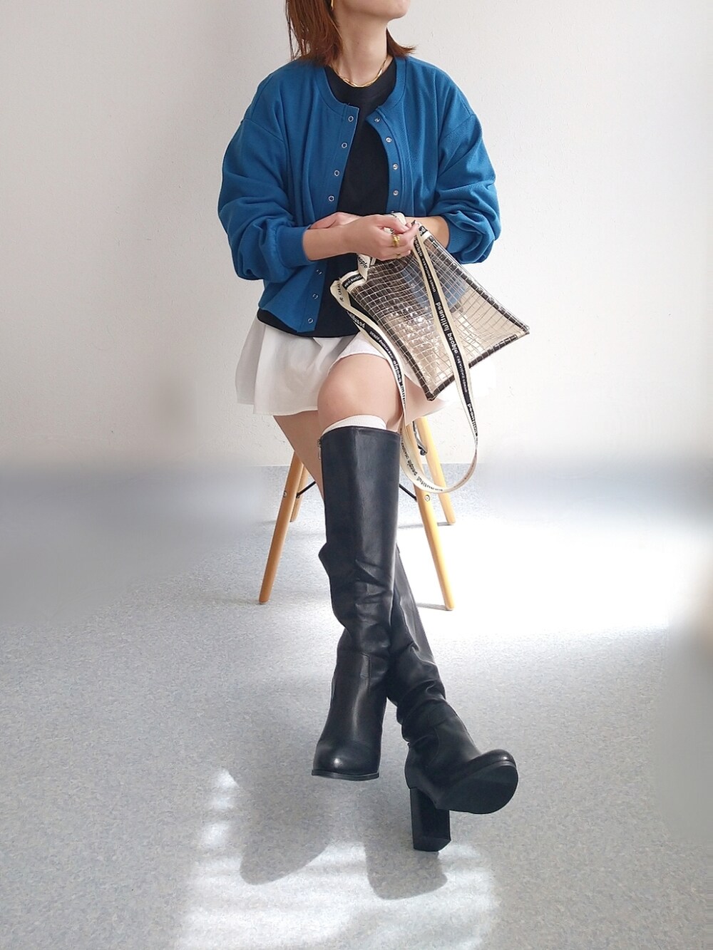 ブルー系のカーディガン/ボレロ、ブラック系のアンサンブル、ブラック系のショルダーバッグを着用したレディースの春コーディネートの2枚目の写真