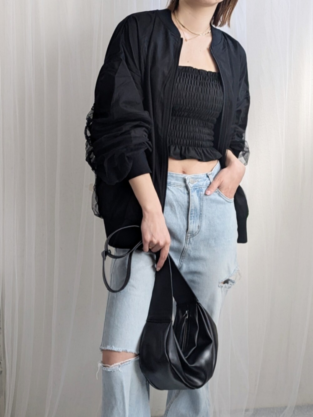 ブラック系のキャミソール、ブラック系のショルダーバッグ、ブラック系のブルゾンを着用したレディースの春コーディネートの3枚目の写真