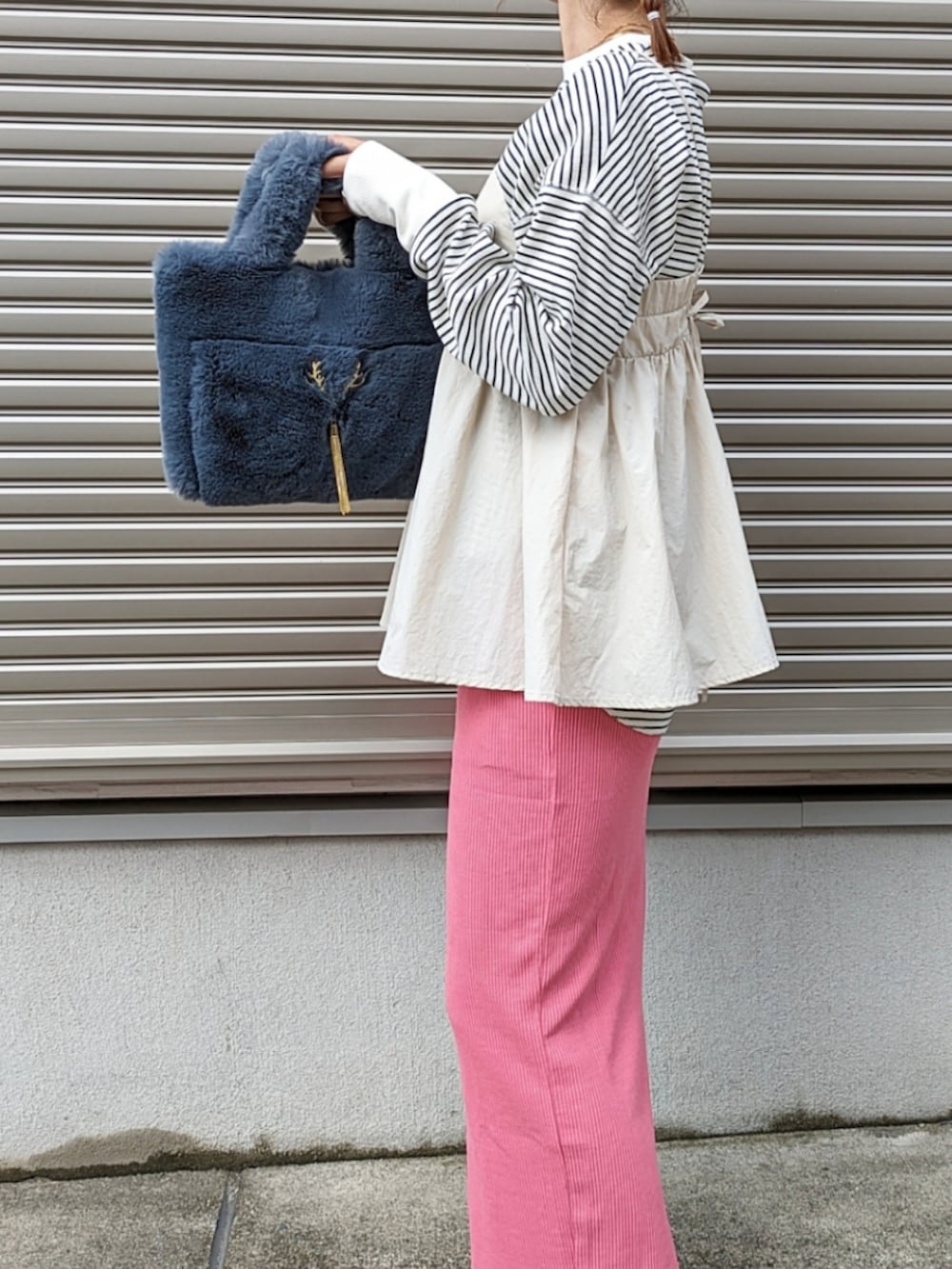 ベージュ系のTシャツ/カットソー、グレー系のハンドバッグ、ピンク系のスカートを着用したレディースの秋コーディネートの3枚目の写真