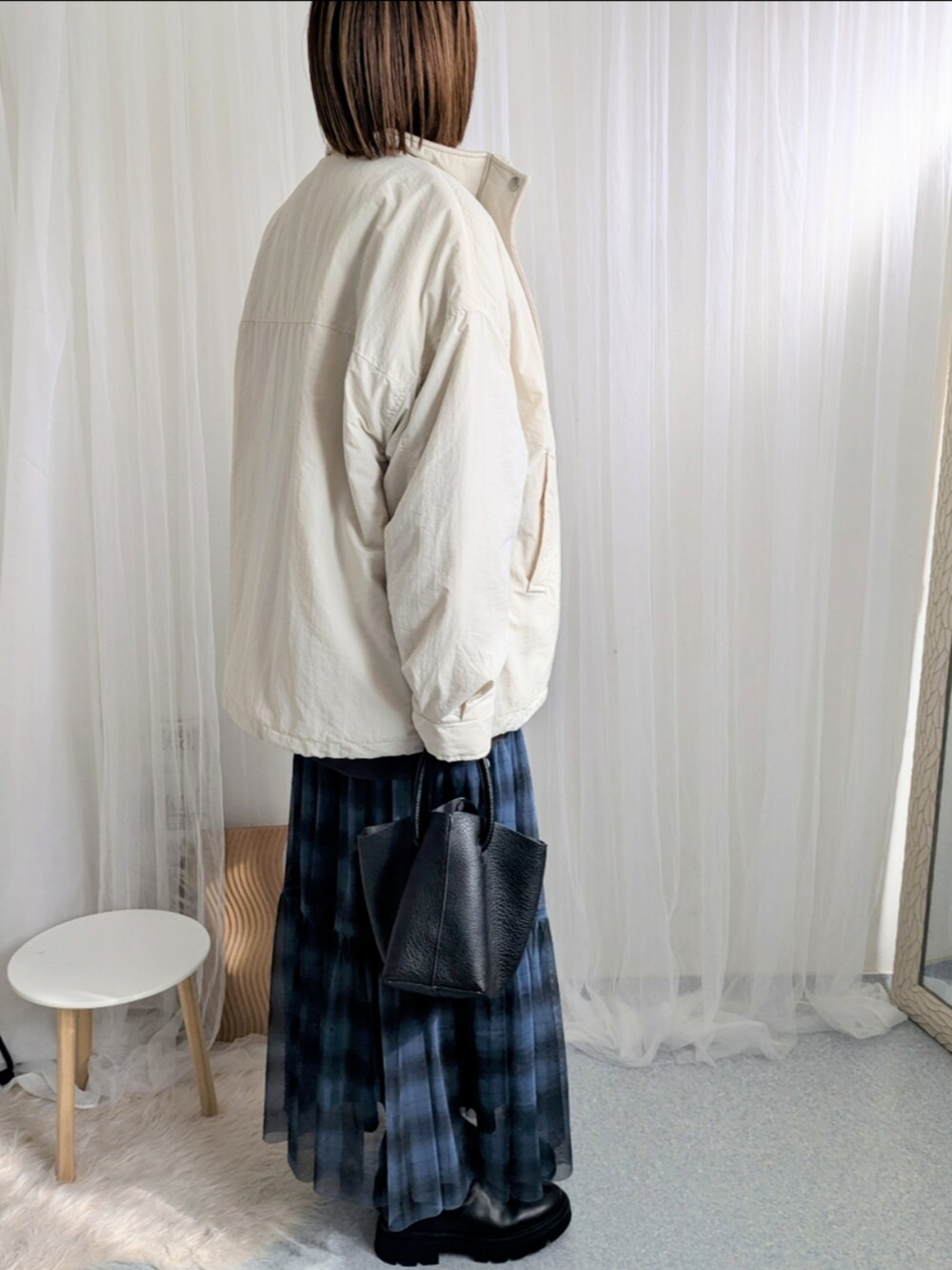 ブルー系のスカート、ブラック系のハンドバッグ、グレー系のスウェットを着用したレディースの秋コーディネートの5枚目の写真