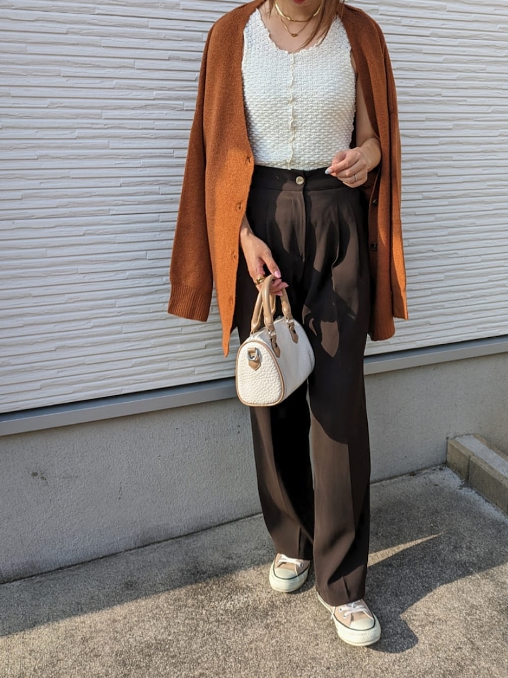 オレンジ系のカーディガン/ボレロ、ホワイト系のタンクトップ、ホワイト系のボストンバッグを着用したレディースの夏コーディネートの3枚目の写真