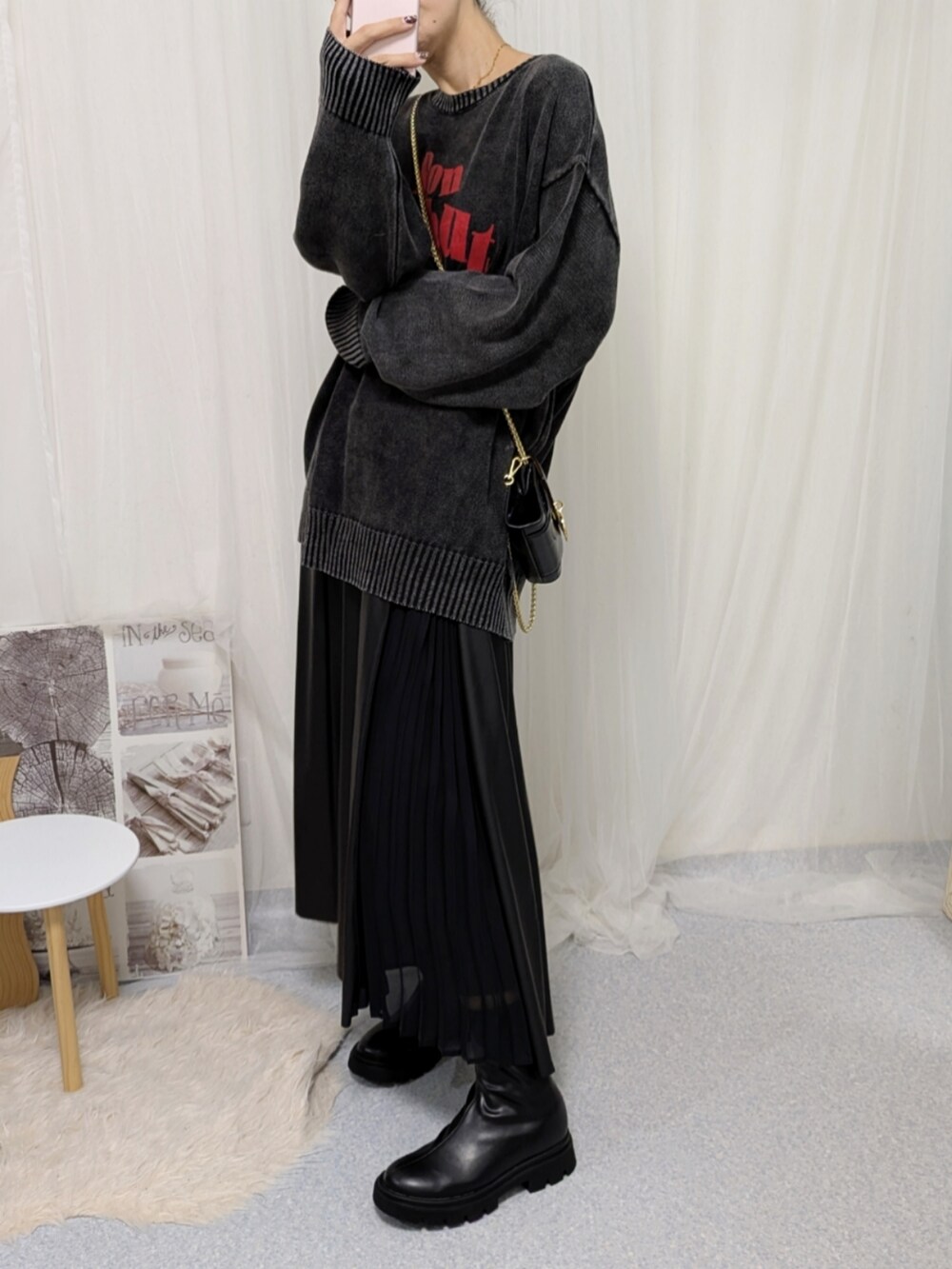 ブラック系のブーツ、ブラック系のニット/セーター、ブラック系のバッグを着用したレディースの秋コーディネートの2枚目の写真