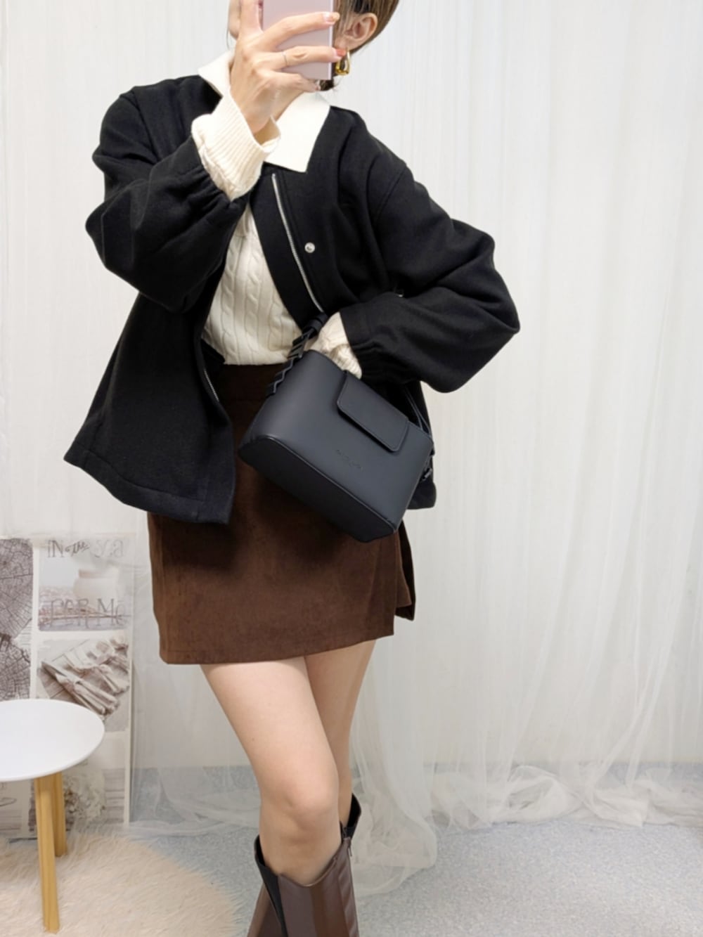 ブラック系のノーカラージャケット、ホワイト系のニット/セーター、ブラック系のショルダーバッグを着用したレディースの秋コーディネートの4枚目の写真