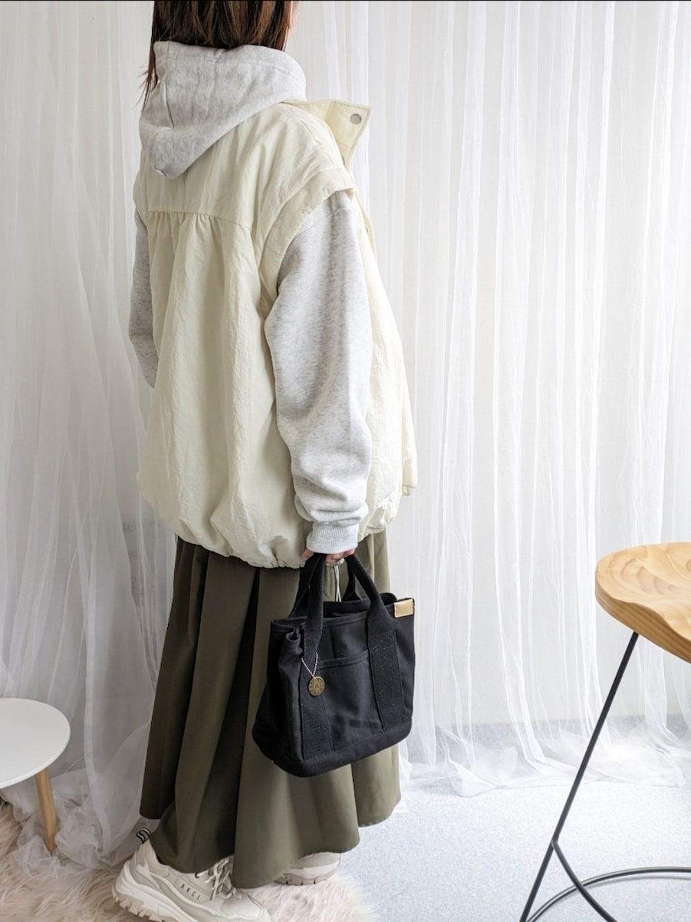 ホワイト系のダウンジャケット/コート、グレー系のパーカー、グリーン系のスカートを着用したレディースの春コーディネートの4枚目の写真