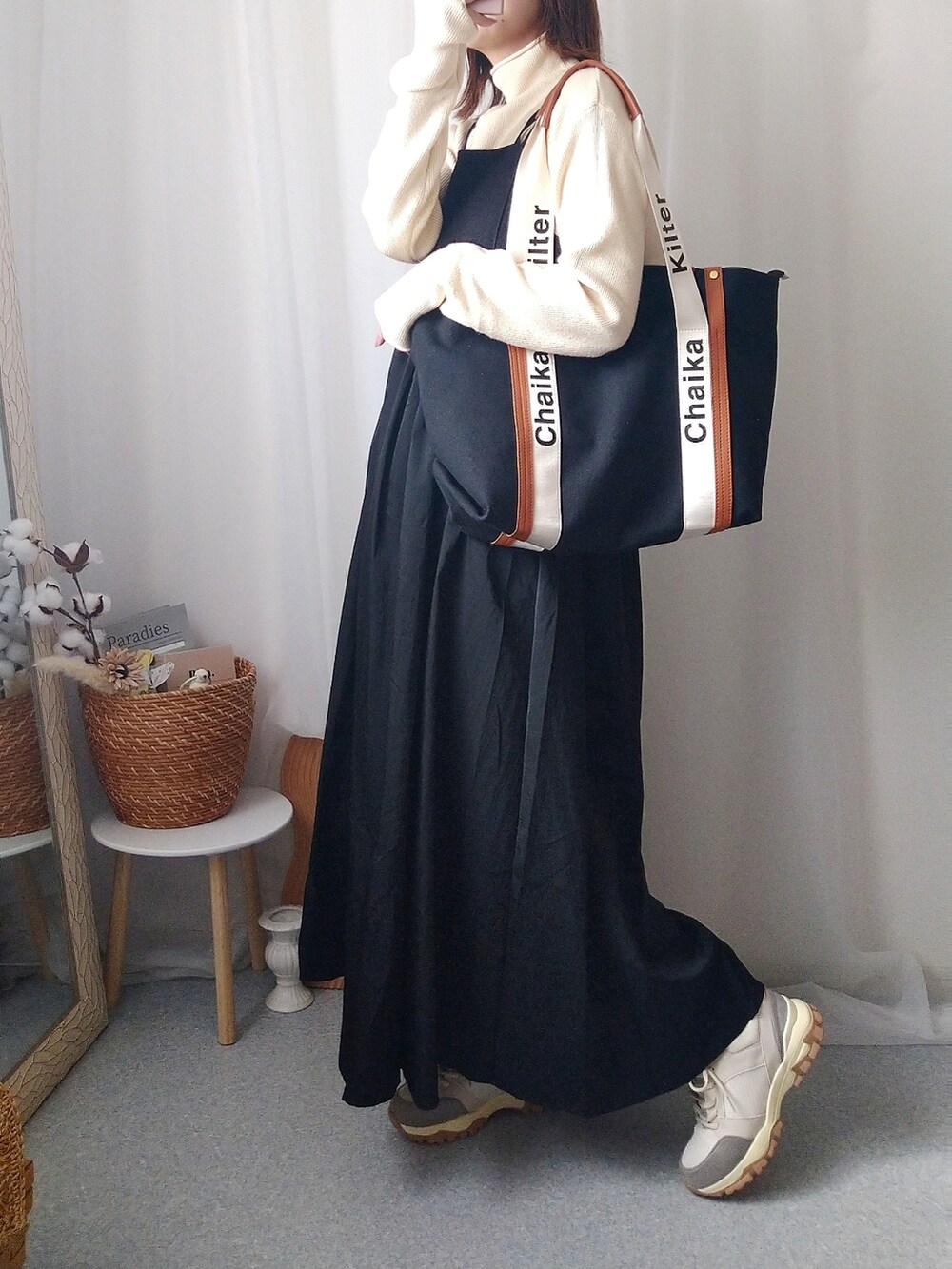 ブラック系のワンピース、ベージュ系のノーカラージャケット、ブラック系のトートバッグを着用したレディースの秋コーディネートの2枚目の写真