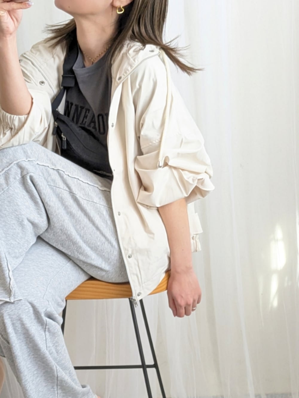 ホワイト系のマウンテンパーカー、ブラック系のTシャツ/カットソー、グレー系のスウェットパンツを着用したレディースの春コーディネートの3枚目の写真