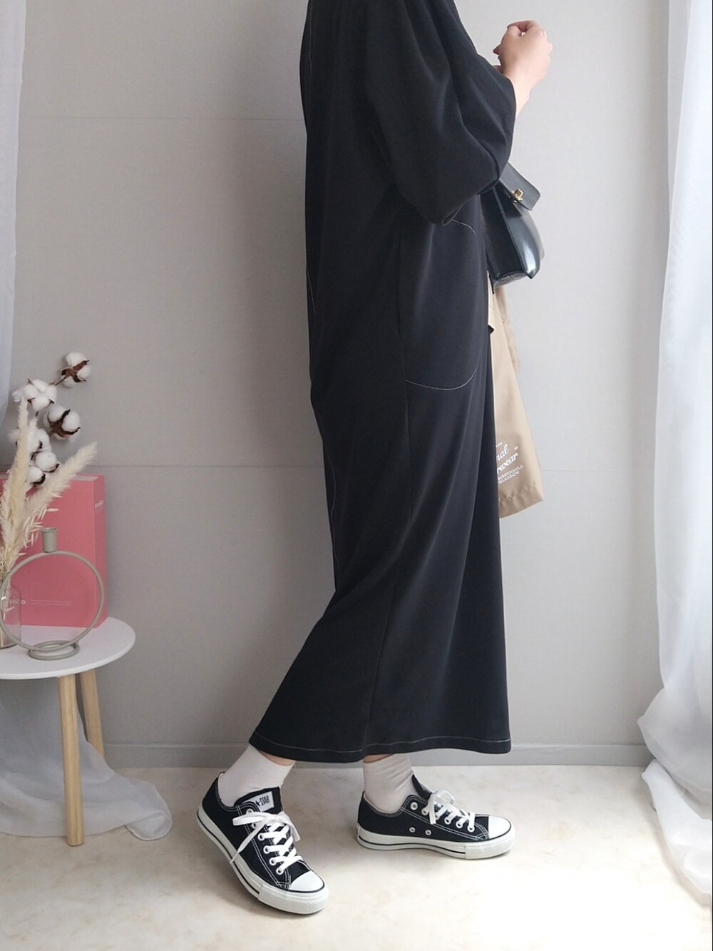 ブラック系のワンピース、ブラック系のショルダーバッグ、ホワイト系のトートバッグを着用したレディースの春コーディネートの4枚目の写真