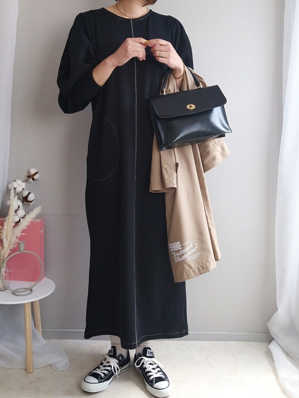 ブラック系のワンピース、ブラック系のショルダーバッグ、ホワイト系のトートバッグを着用したレディースの春コーディネートの2枚目の写真