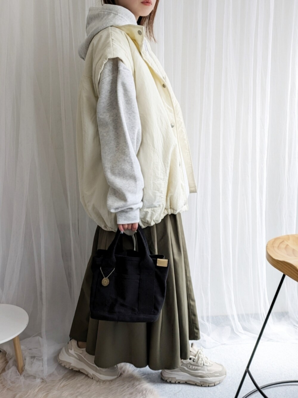 ホワイト系のダウンジャケット/コート、グレー系のパーカー、グリーン系のスカートを着用したレディースの春コーディネートの5枚目の写真