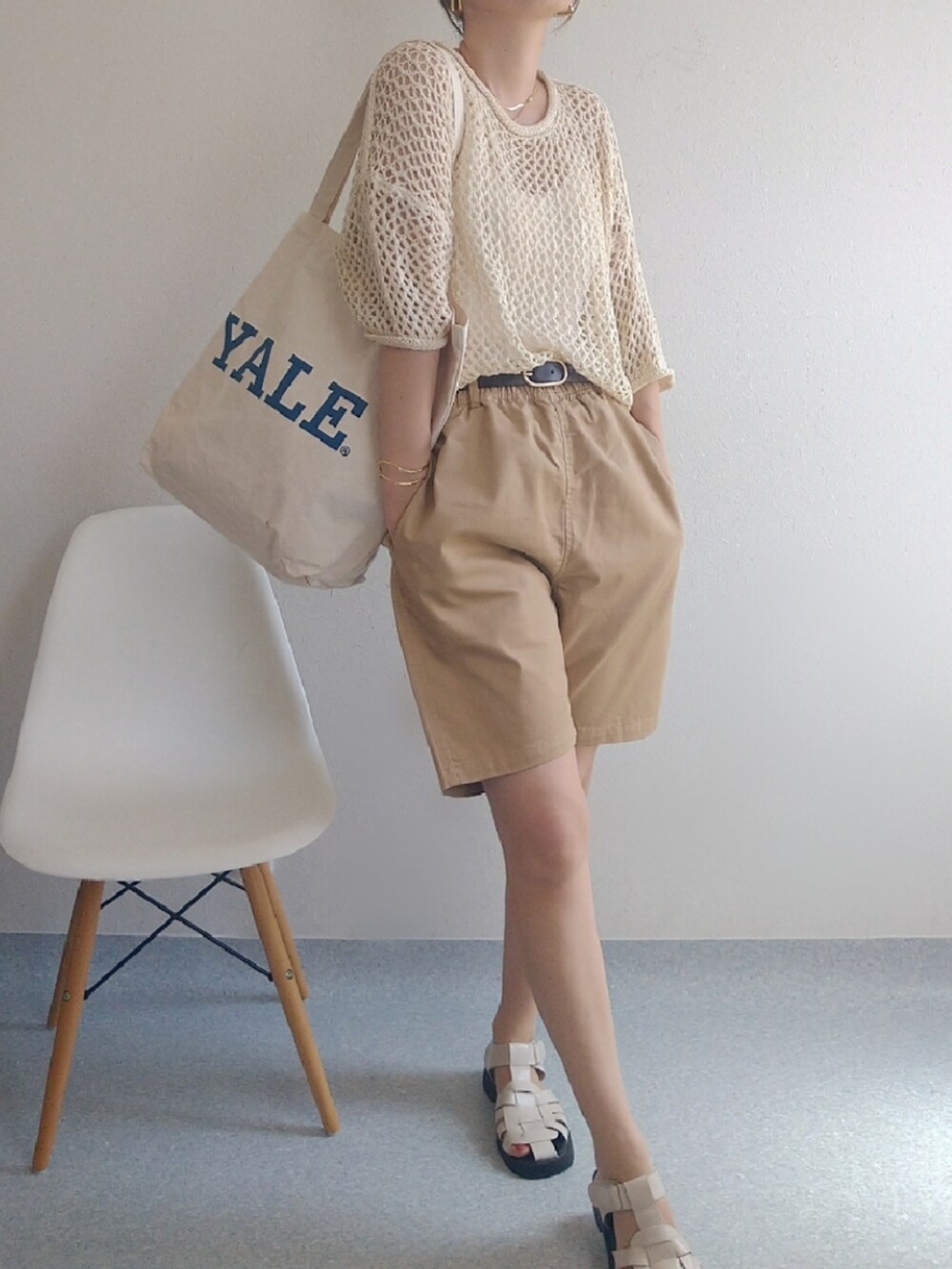 ホワイト系のニット/セーター、ホワイト系のトートバッグ、ベージュ系のサンダルを着用したレディースの春コーディネートの2枚目の写真