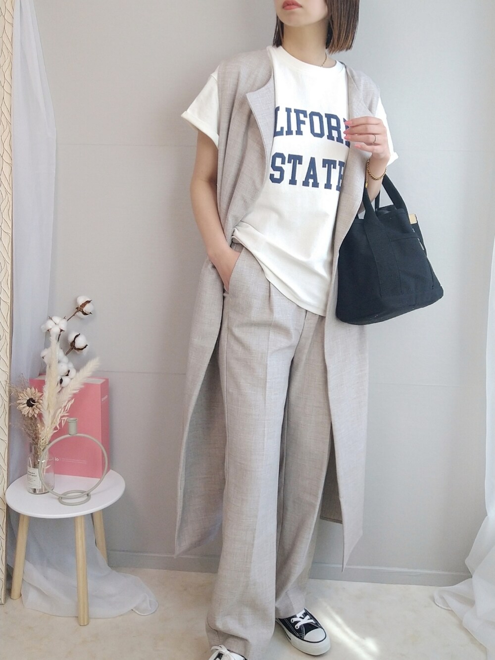 ホワイト系のTシャツ/カットソー、ベージュ系のベスト、ベージュ系のスラックスを着用したレディースの春コーディネートの2枚目の写真