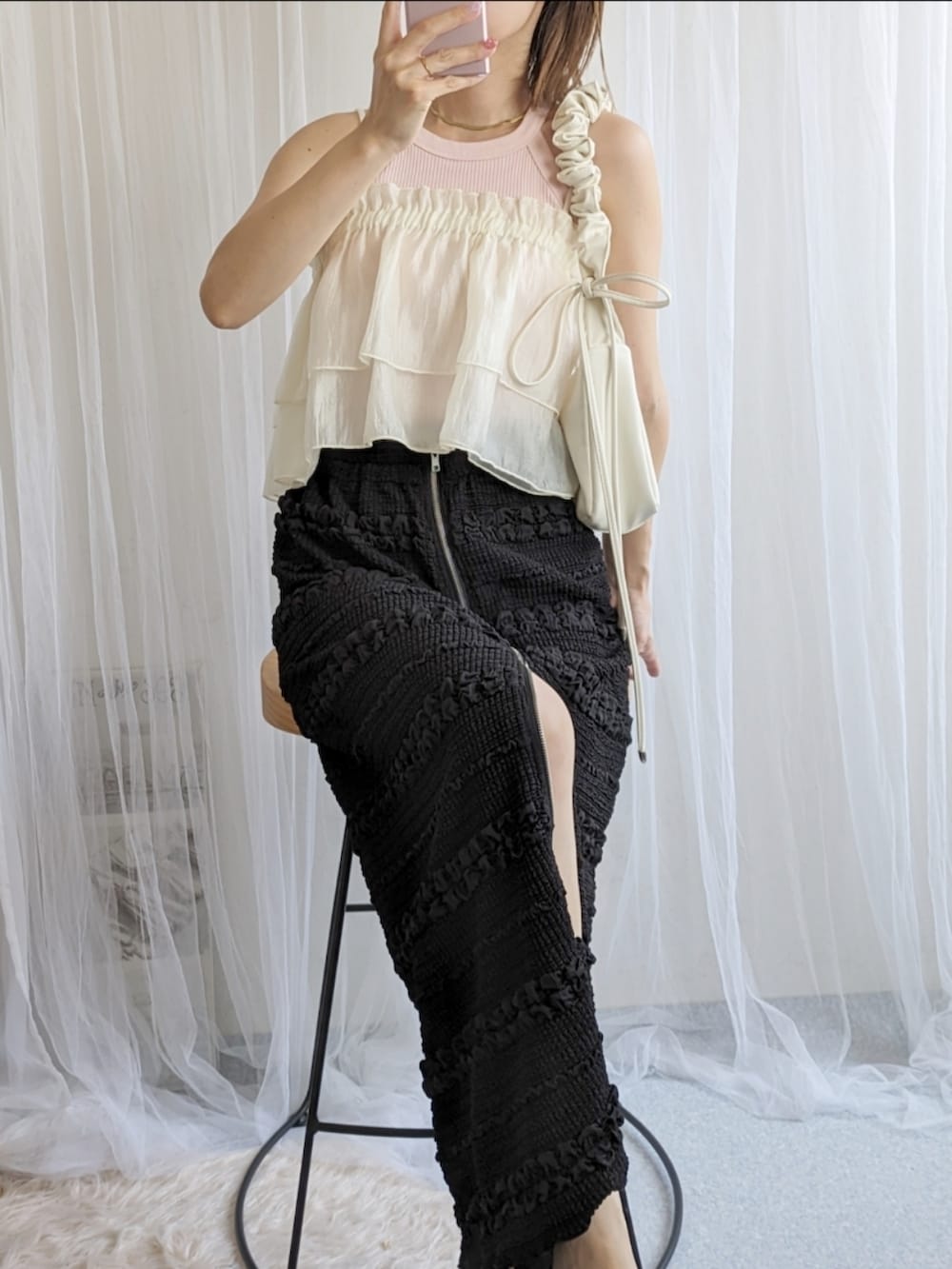 ホワイト系のショルダーバッグ、ブラック系のスカート、ホワイト系のキャミソールを着用したレディースの夏コーディネートの2枚目の写真