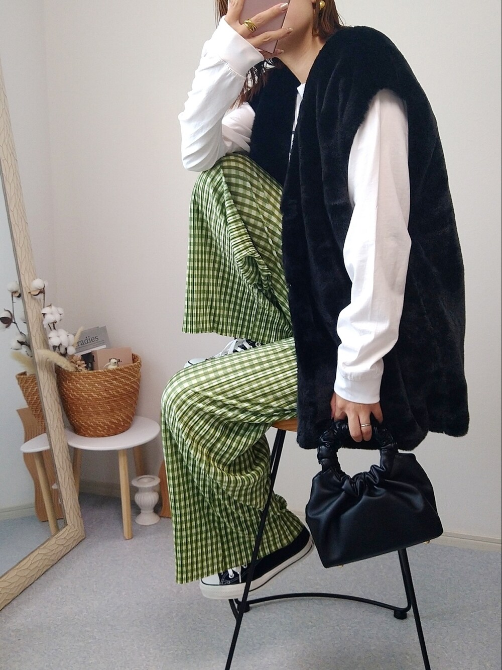 ホワイト系のTシャツ/カットソー、ブラック系のベスト、ブラック系のショルダーバッグを着用したレディースの秋コーディネートの2枚目の写真