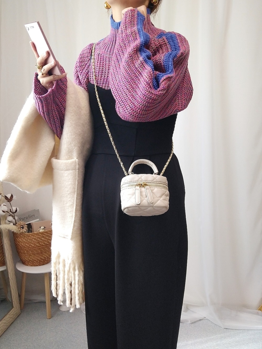 ピンク系のニット/セーター、ブラック系のサロペット/オーバーオール、ホワイト系のショルダーバッグを着用したレディースの秋コーディネートの3枚目の写真