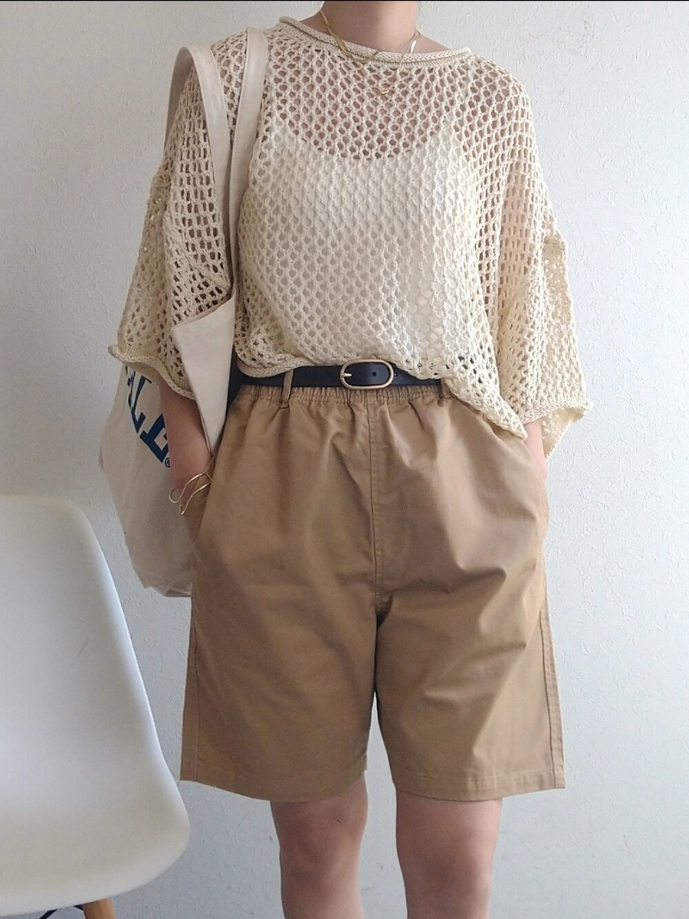 ホワイト系のニット/セーター、ホワイト系のトートバッグ、ベージュ系のサンダルを着用したレディースの春コーディネートの4枚目の写真