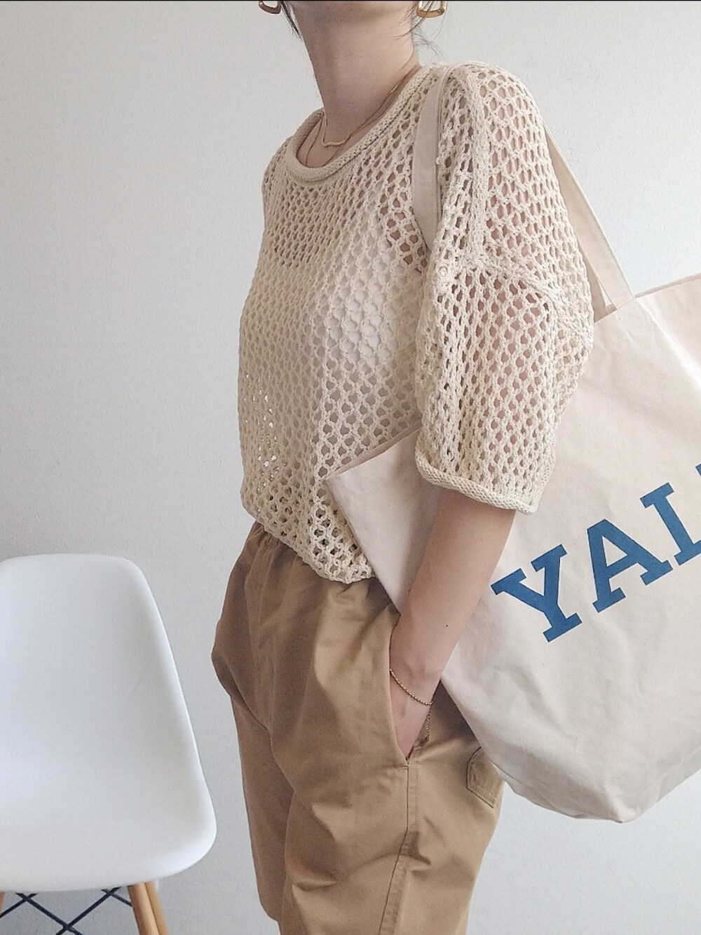 ホワイト系のニット/セーター、ホワイト系のトートバッグ、ベージュ系のサンダルを着用したレディースの春コーディネートの3枚目の写真