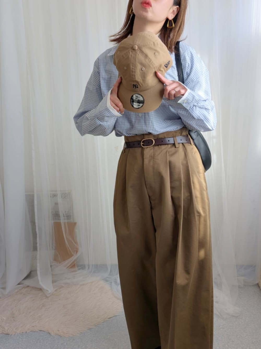 ブルー系のシャツ/ブラウス、ブラック系のバッグ、ブラウン系のパンツを着用したレディースの冬コーディネートの3枚目の写真