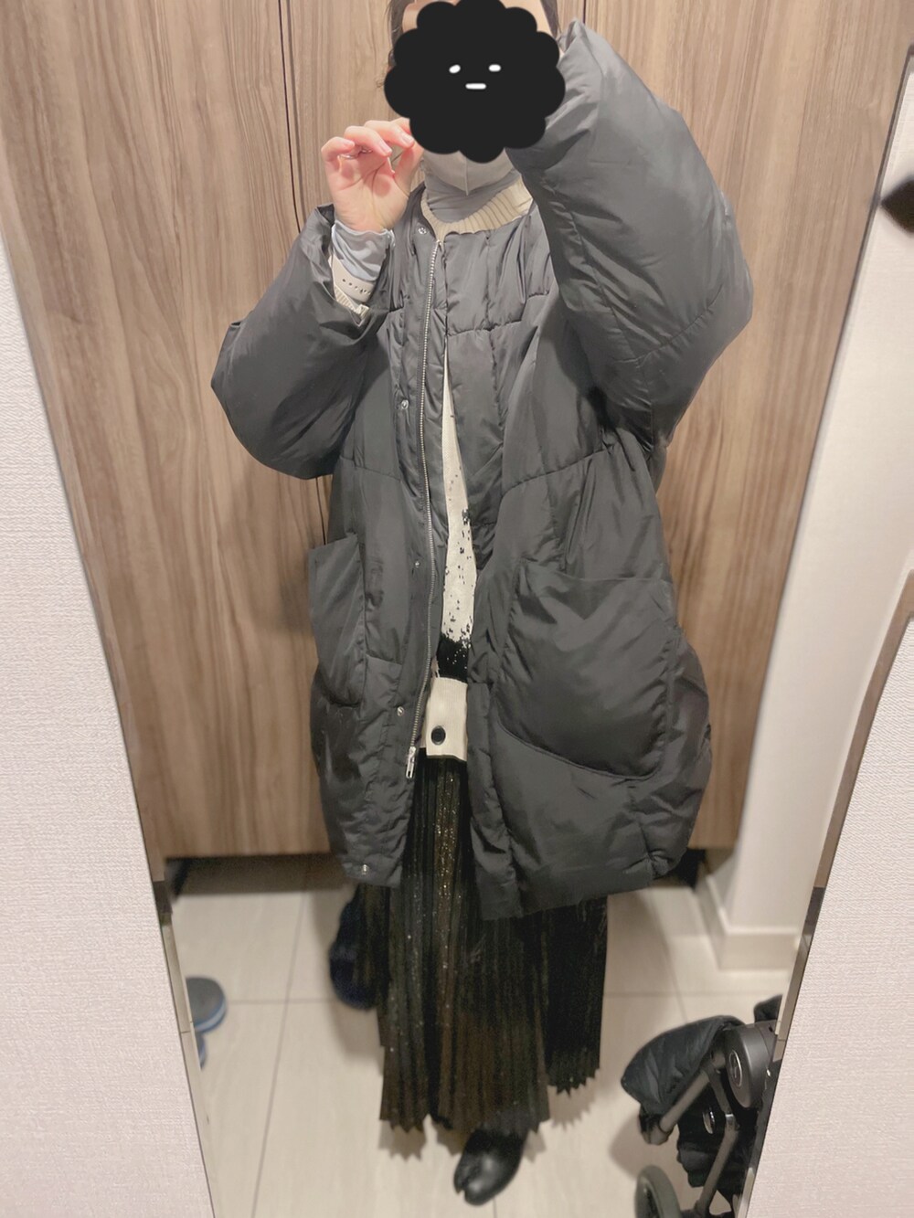 ブラック系のスカート、ブラック系のダウンジャケット/コート、ホワイト系のカーディガン/ボレロを着用したレディースの冬コーディネートの2枚目の写真