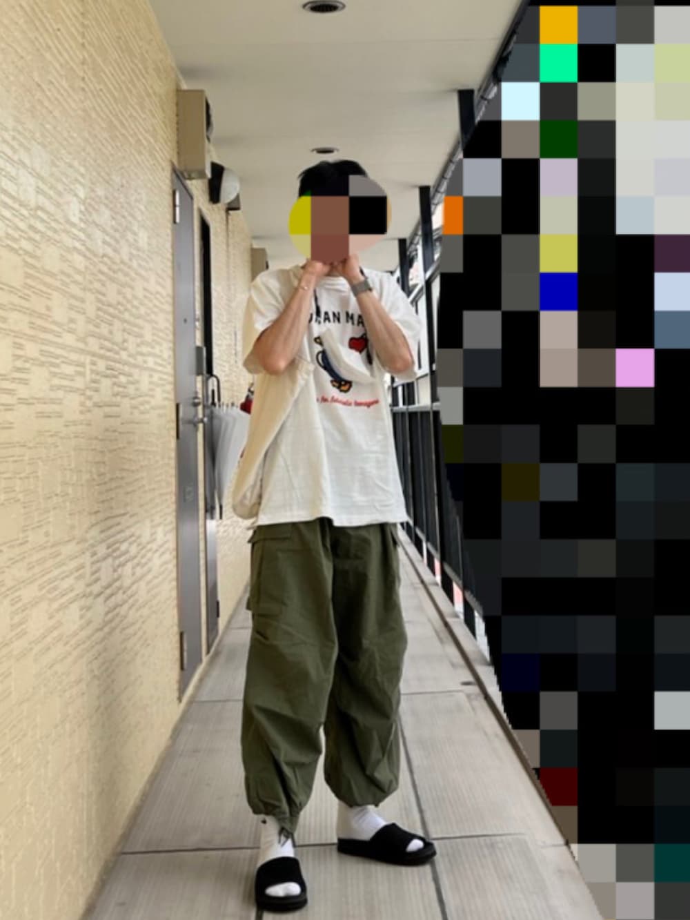 ホワイト系のTシャツ/カットソー、グリーン系のカーゴパンツ、ブラック系のサンダルを着用したメンズの夏コーディネートの2枚目の写真