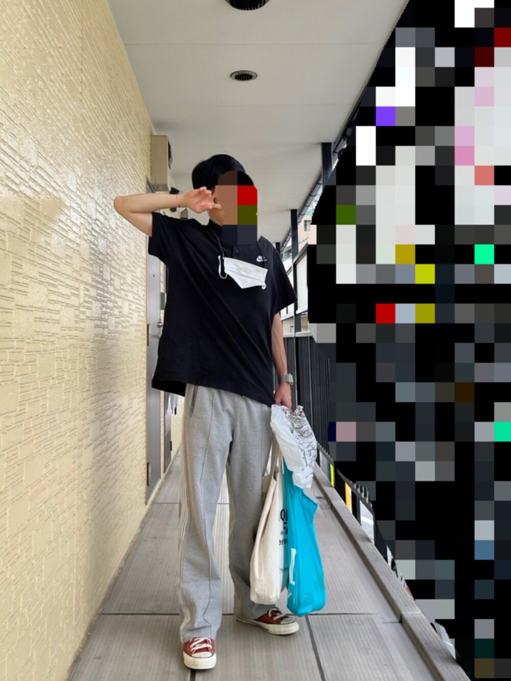 ブラック系のポロシャツ、グレー系のスウェットパンツ、オレンジ系のスニーカーを着用したメンズの秋コーディネートの3枚目の写真