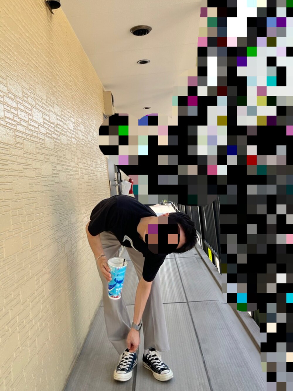 ブラック系のTシャツ/カットソー、グレー系のスラックス、ブラック系のスニーカーを着用したメンズの夏コーディネートの2枚目の写真