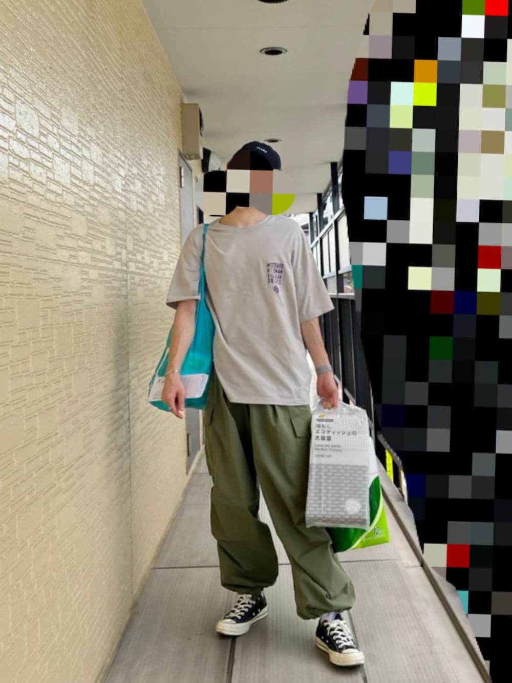 グリーン系のカーゴパンツ、グレー系のTシャツ/カットソー、ブラック系のスニーカーを着用したメンズの夏コーディネートの2枚目の写真