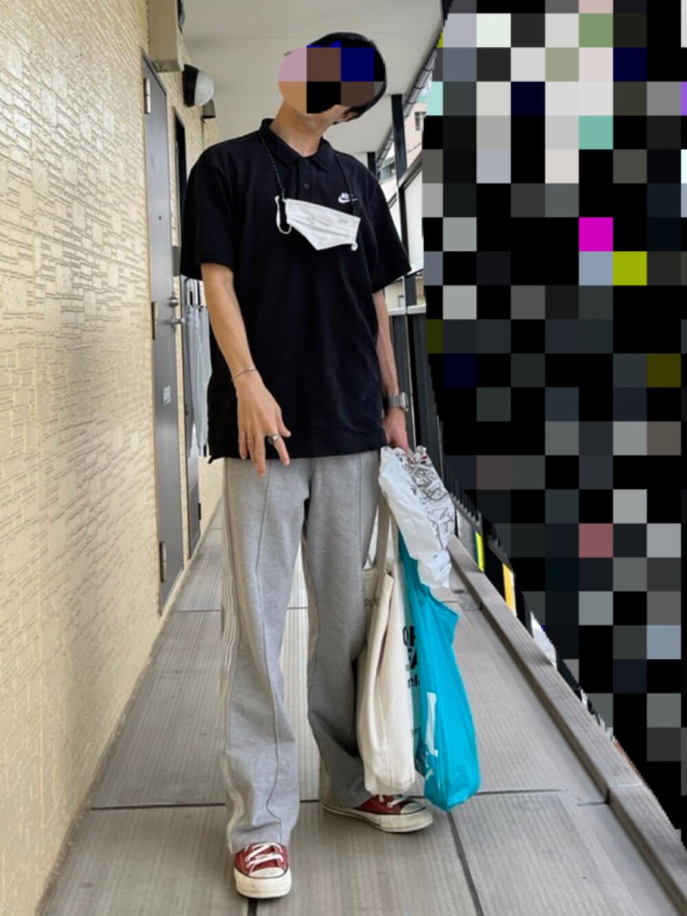 ブラック系のポロシャツ、グレー系のスウェットパンツ、オレンジ系のスニーカーを着用したメンズの秋コーディネートの2枚目の写真